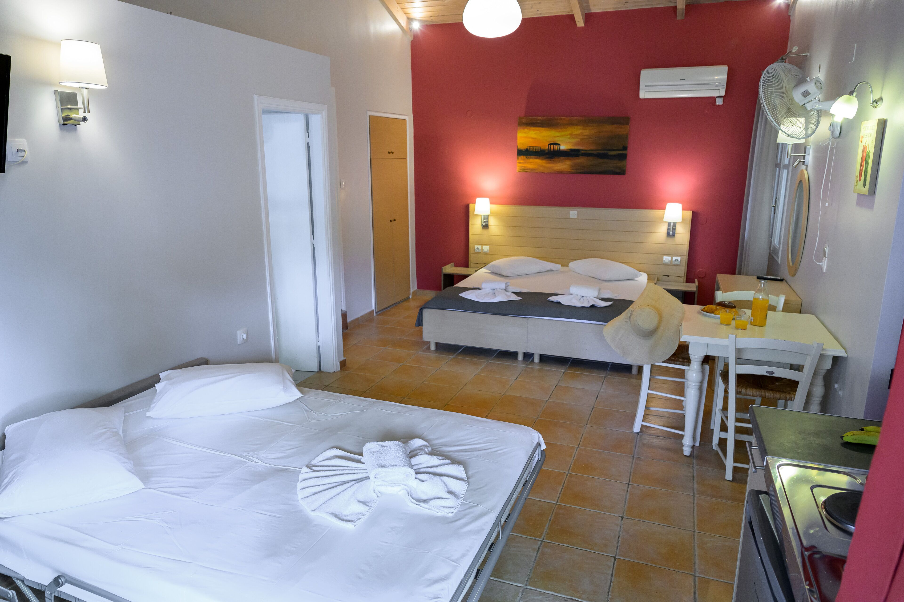 Quarto de hotel com cama, escrivaninha, cadeira e mesa de jantar.