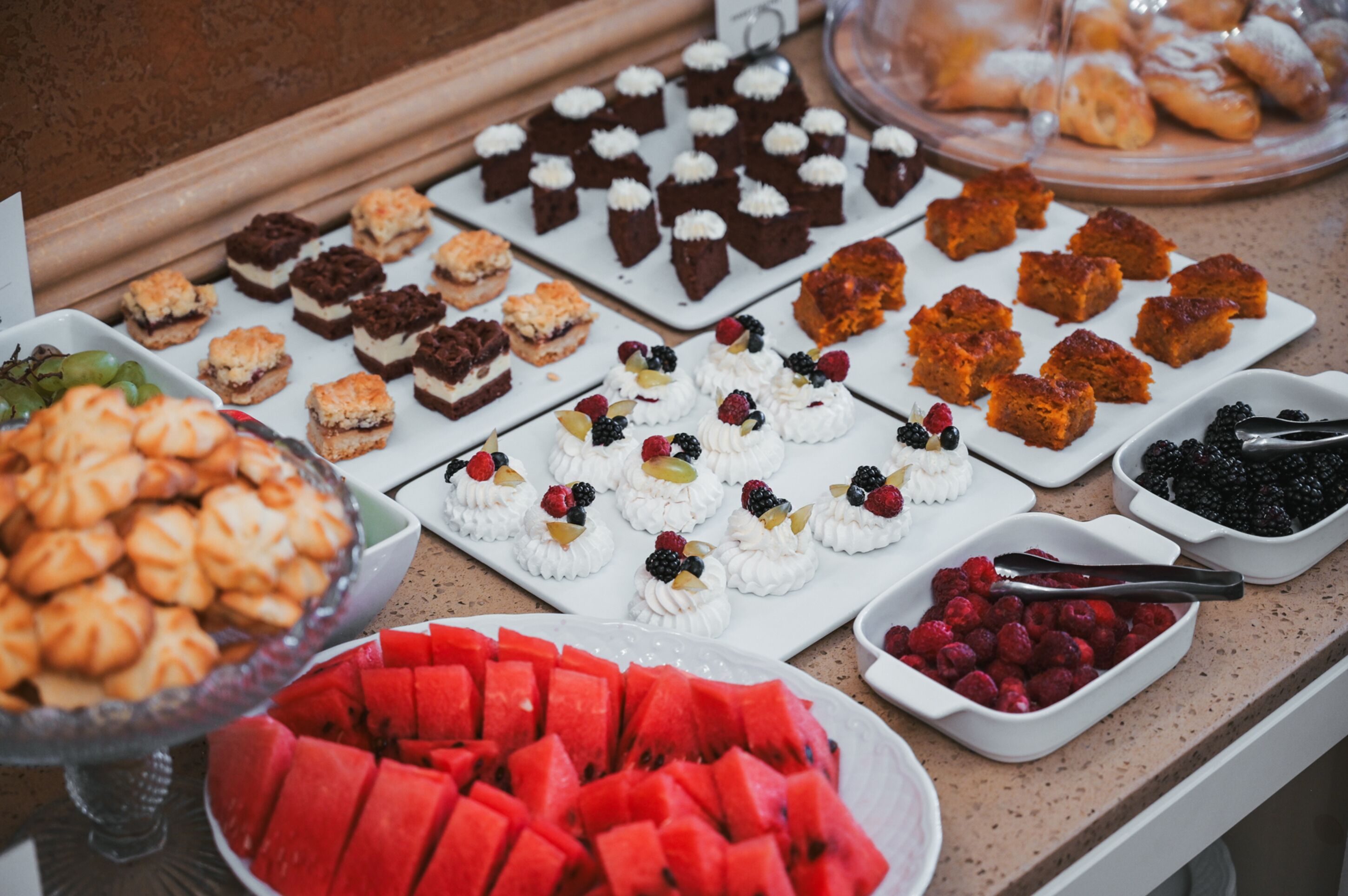 A buffet with various desserts and fruits.