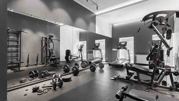 A gym with weightlifting equipment, treadmills, and exercise machines.