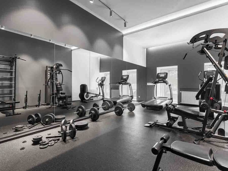 A gym with weightlifting equipment, treadmills, and exercise machines.