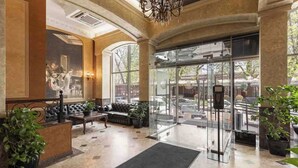 A lobby with a reception desk, seating area, and large windows. - Aleksandrovskiy Hotel (Odesa)