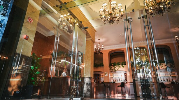 A modern interior with glass walls, chandeliers, and bar seating. - Aleksandrovskiy Hotel (Odesa)
