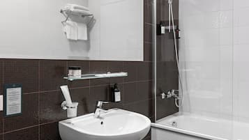 A modern bathroom with a white sink, a glass shower enclosure, and a white bathtub.
