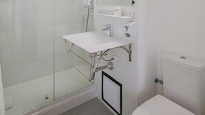 A modern bathroom with a glass-enclosed shower, a white sink with a mirror above, and a toilet. - Hôtel Amaya (Ambares-et-Lagrave)
