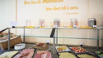 A buffet with various food items and a quote on the wall.