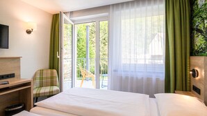 Une chambre d’hôtel avec un lit, une chaise, un bureau et un téléviseur.