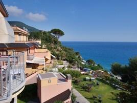 Un hotel con terraza y vistas al mar, incluyendo una montaña.