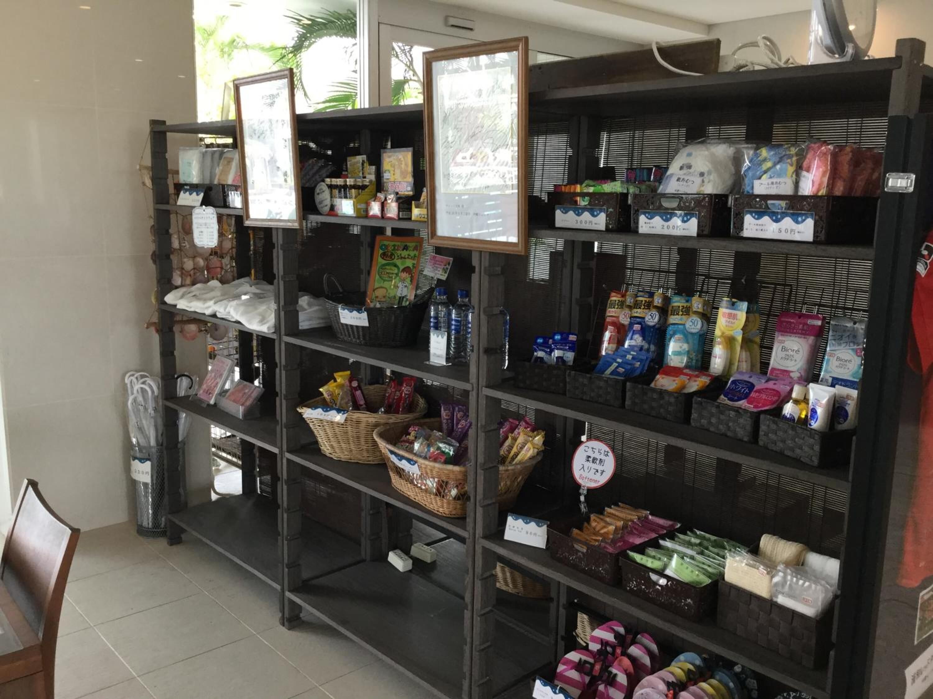 Una tienda con estantes llenos de diversos productos, como aperitivos, bebidas y artículos para el hogar.