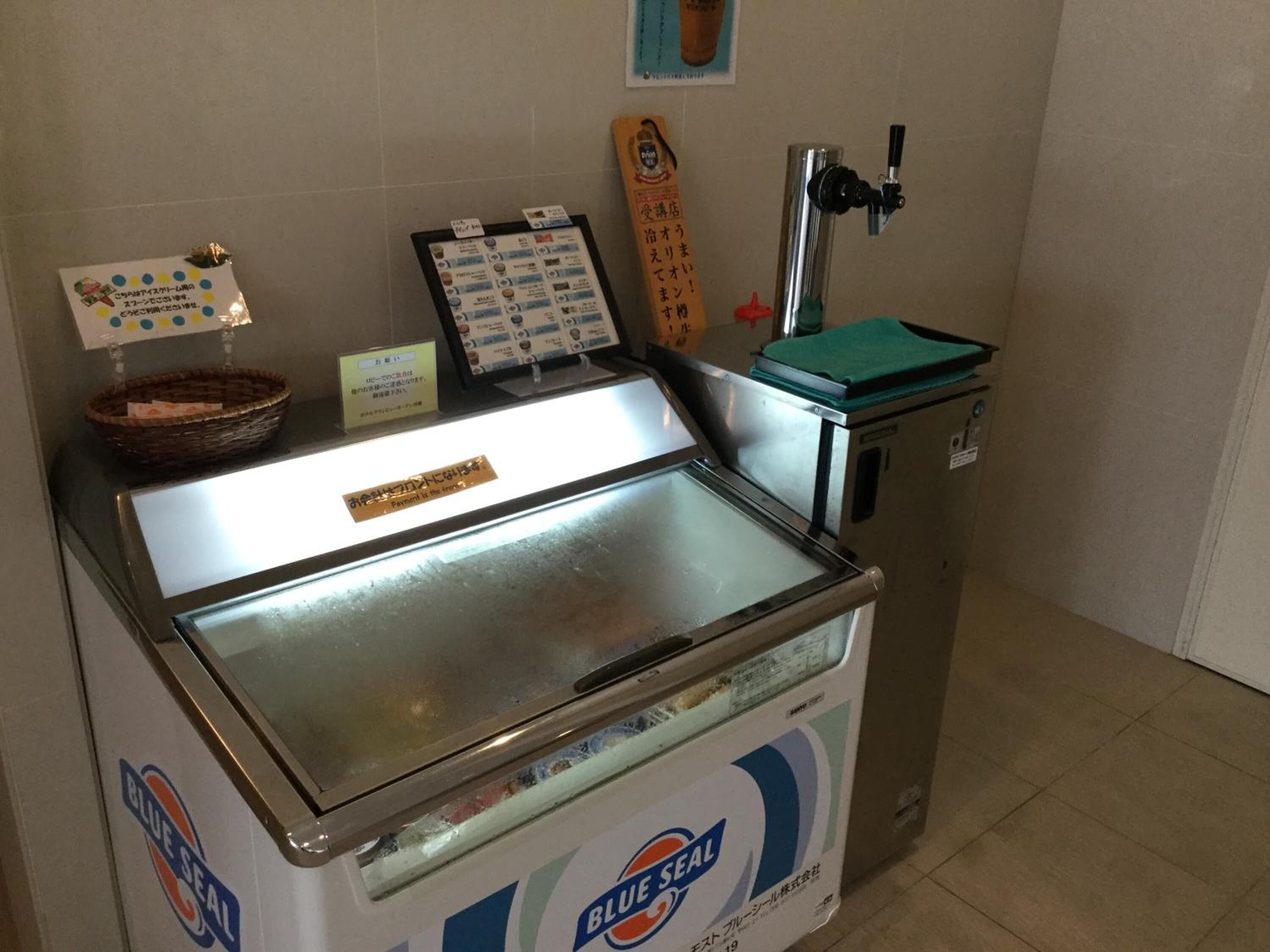 Pequeño congelador de helados con un cartel que indica que el pago se realiza en el recipiente.