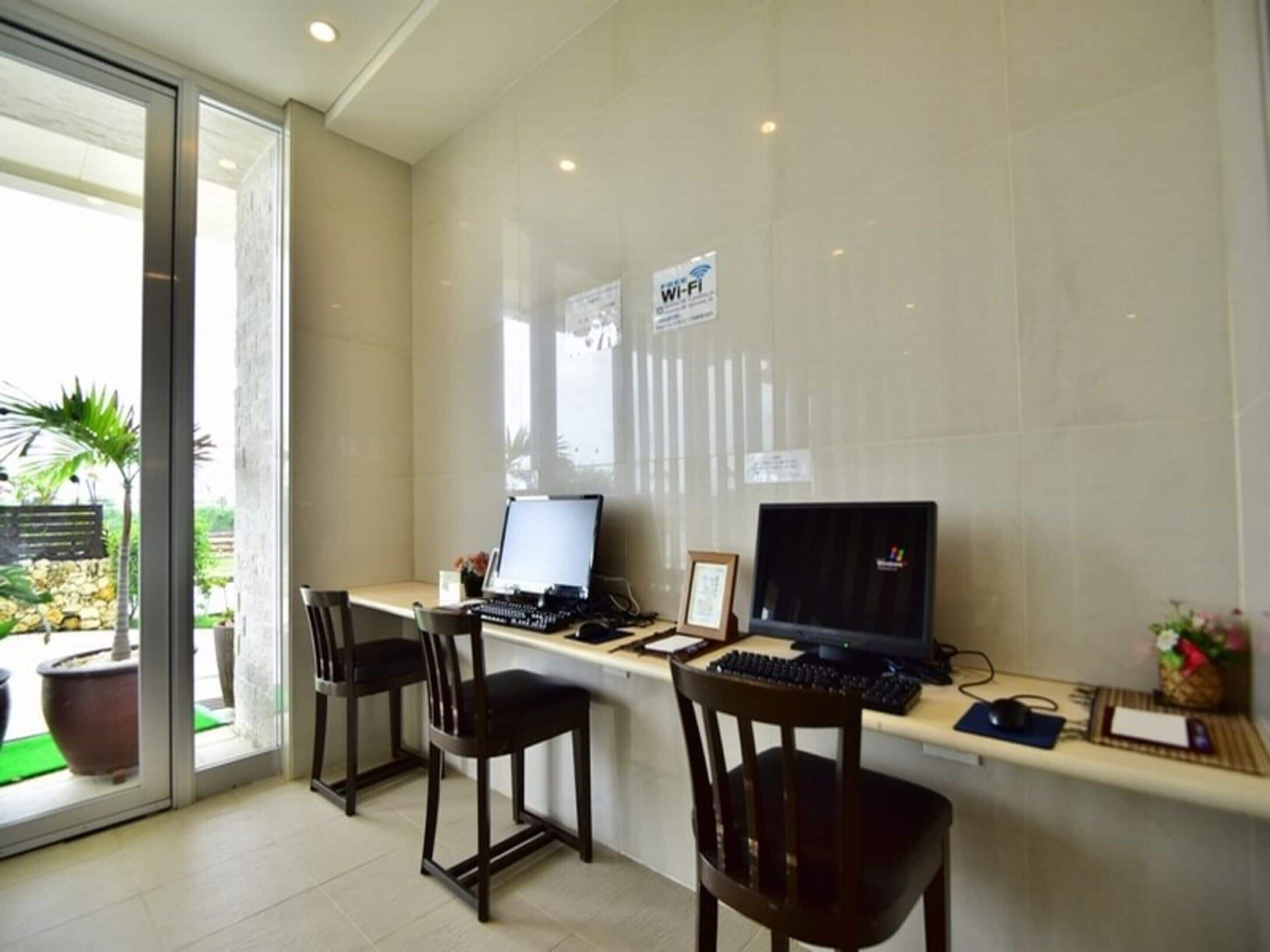 A modern office space with two desks, computers, and chairs.
