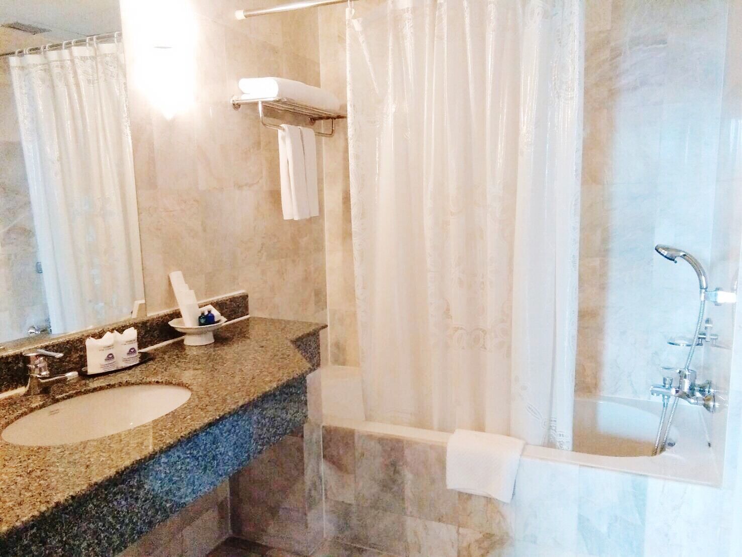 A bathroom with a marble sink, a bathtub, and a shower.