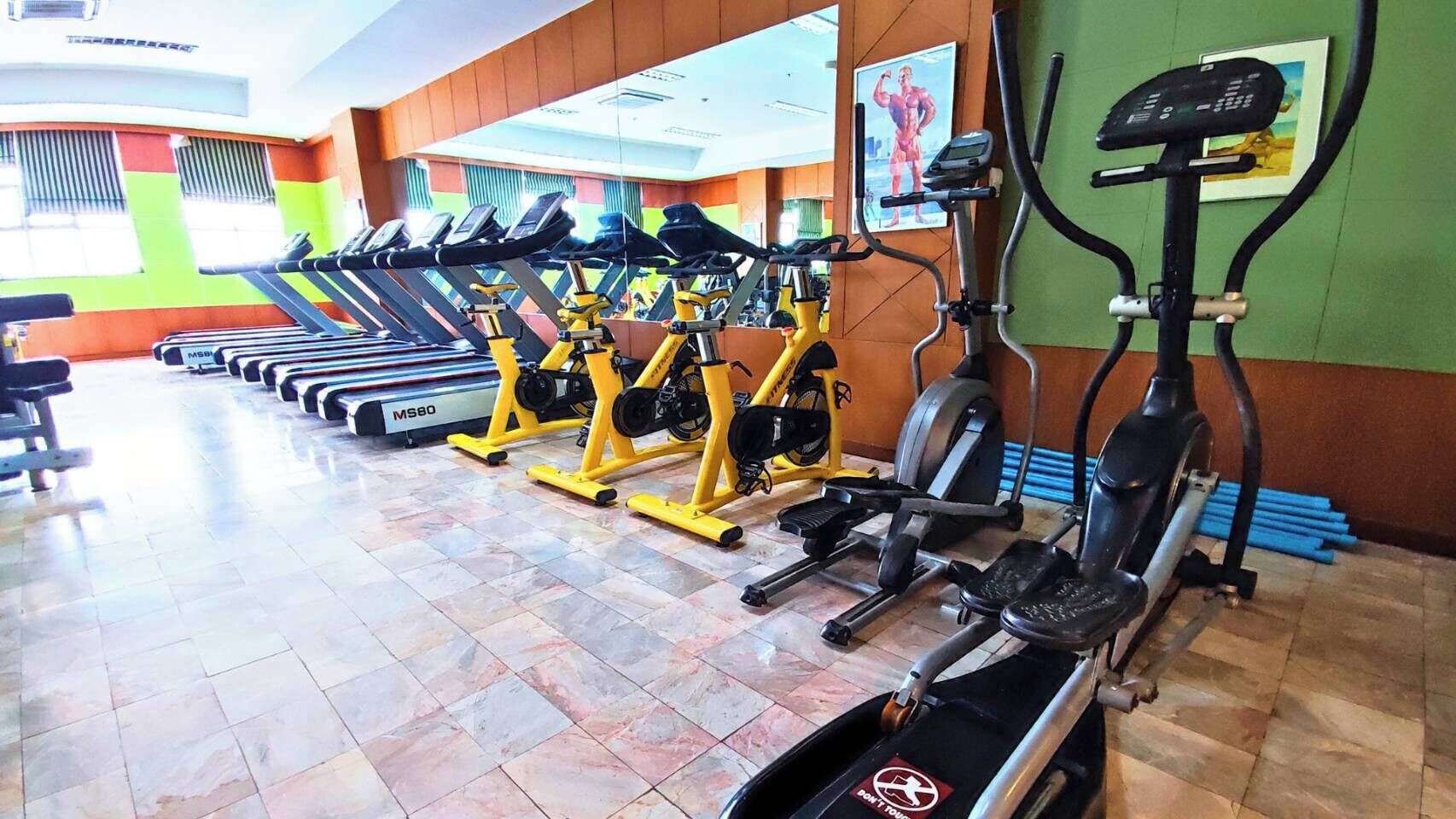 A gym with treadmills, stationary bikes, and elliptical machines.