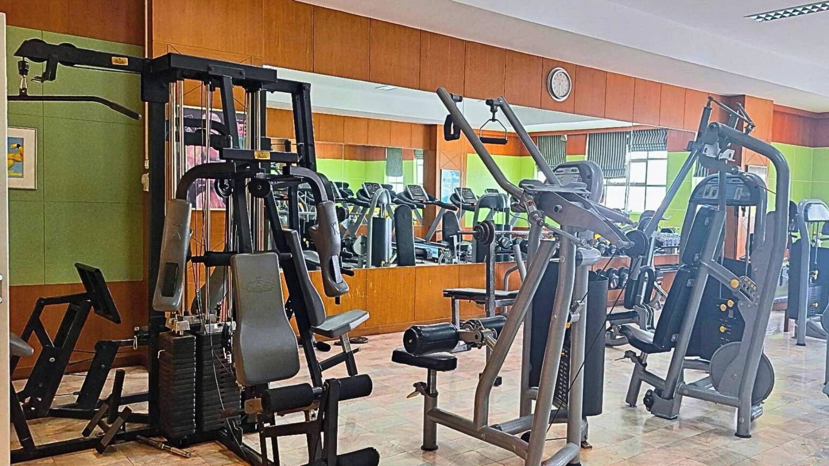 A gym with various exercise machines, including weight stacks and cardio equipment.