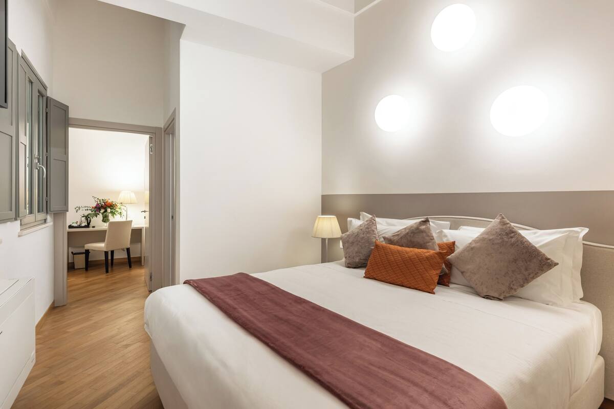 Una habitación de hotel con una cama, un escritorio y una silla.