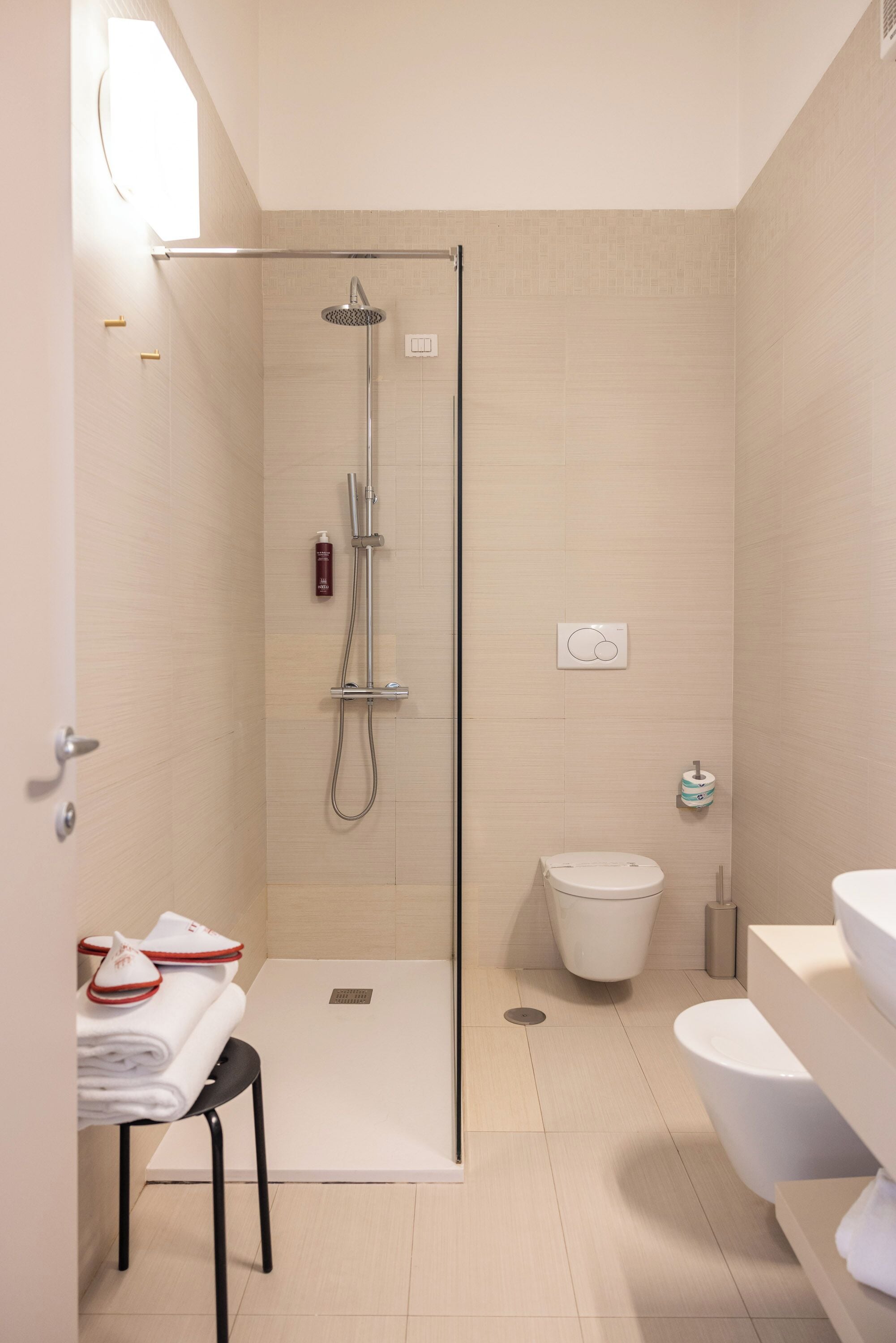 Un baño moderno con ducha de vidrio, inodoro y lavamanos.