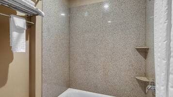 A bathroom with a bathtub, a towel rack, and a shower area.