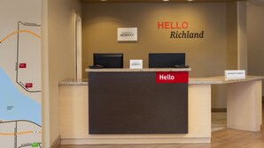 Un mostrador de recepción con un letrero que dice 'Hello', dos monitores y la señalización de 'Marriott Bonvoy'.