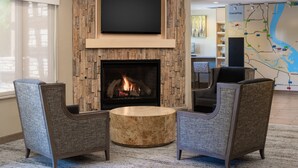 Una sala de estar moderna con chimenea, asientos cómodos, un televisor de pantalla plana y un mapa en la pared.