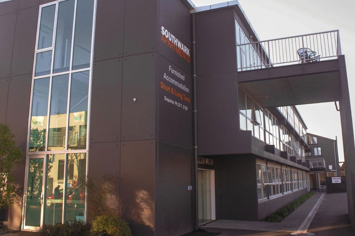 A modern building with a sign indicating furnished accommodation and long-term short-term options.