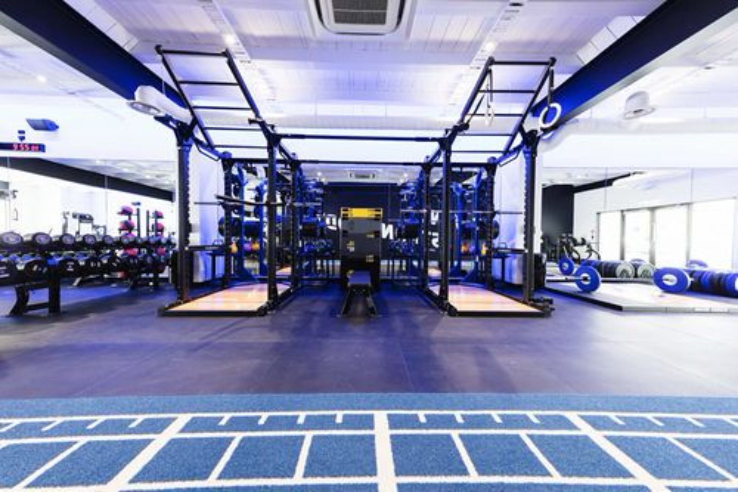 Un gimnasio con equipamiento de levantamiento de pesas, cintas de correr y pelotas de ejercicio.