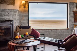 Una sala de estar acogedora con un ventanal grande, una chimenea y un espacio de estar confortable.