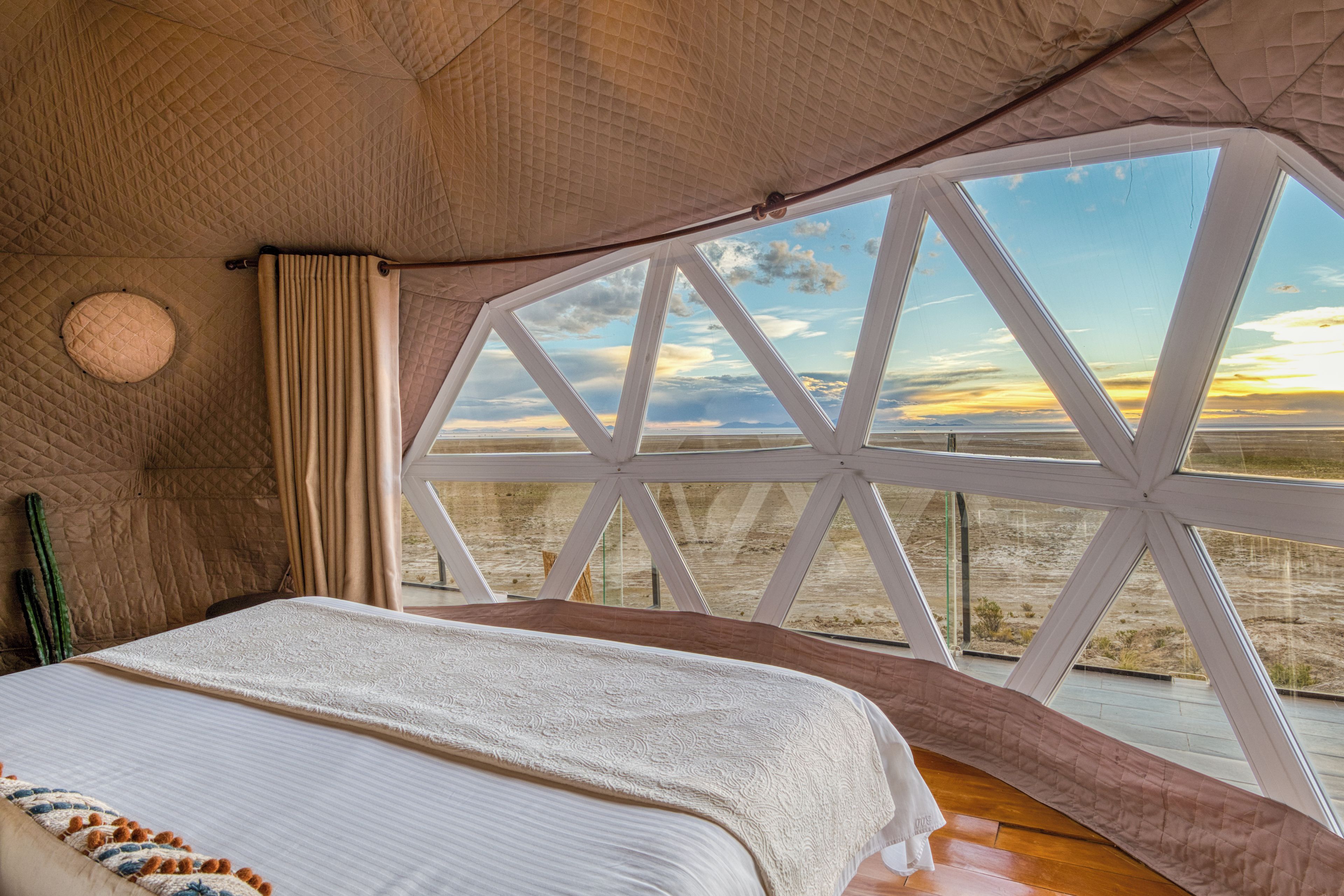 Una habitación con cama, ventana y vistas al paisaje.