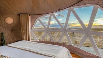 Una habitación con cama, ventana y vistas al paisaje.