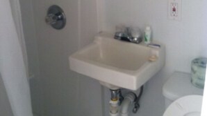 Un baño con lavabo, espejo e inodoro.