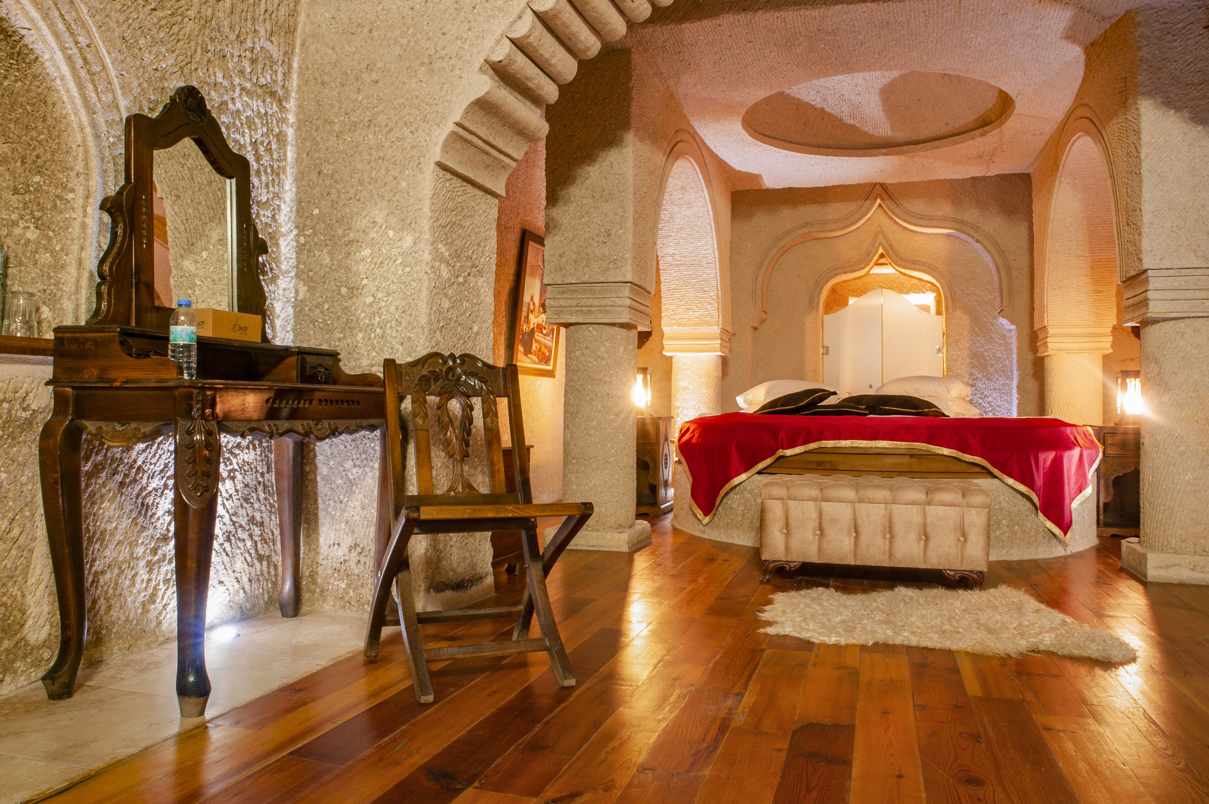 Une chambre à coucher avec un lit en bois, une chaise, un bureau et un miroir.