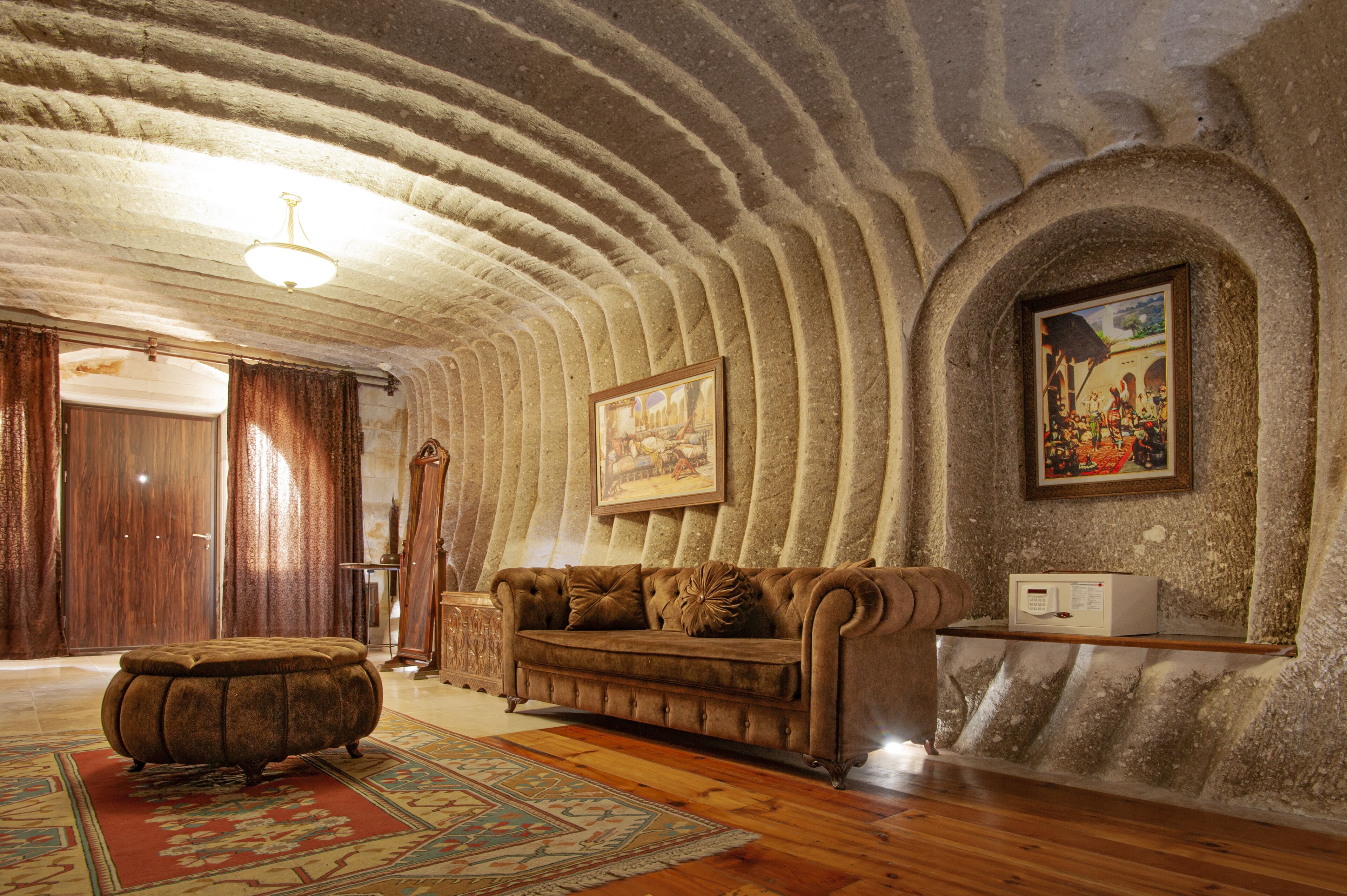 A room with a vintage sofa, a patterned rug, and a framed painting on the wall.