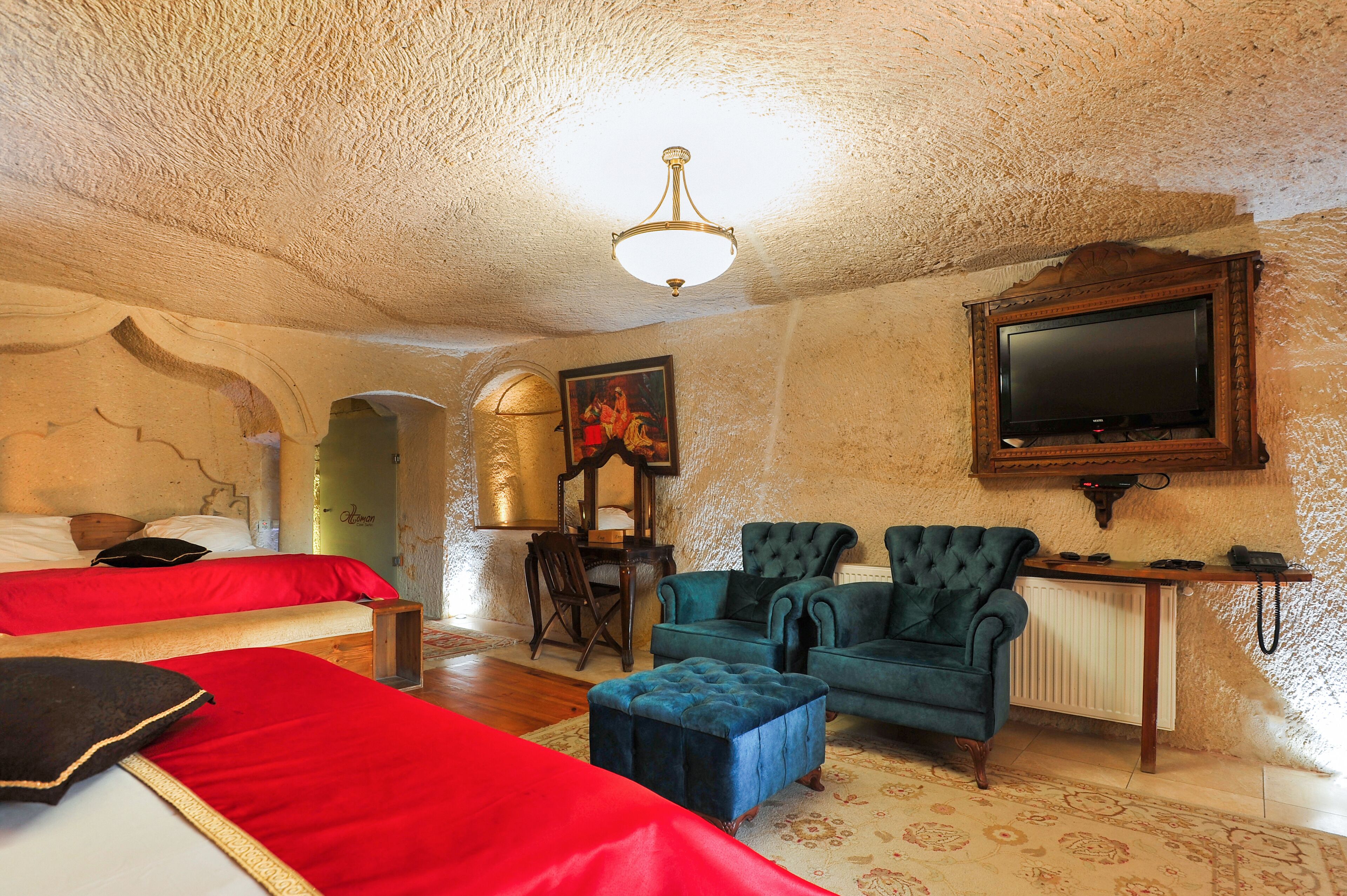 A room with two beds, a television, and a fireplace.
