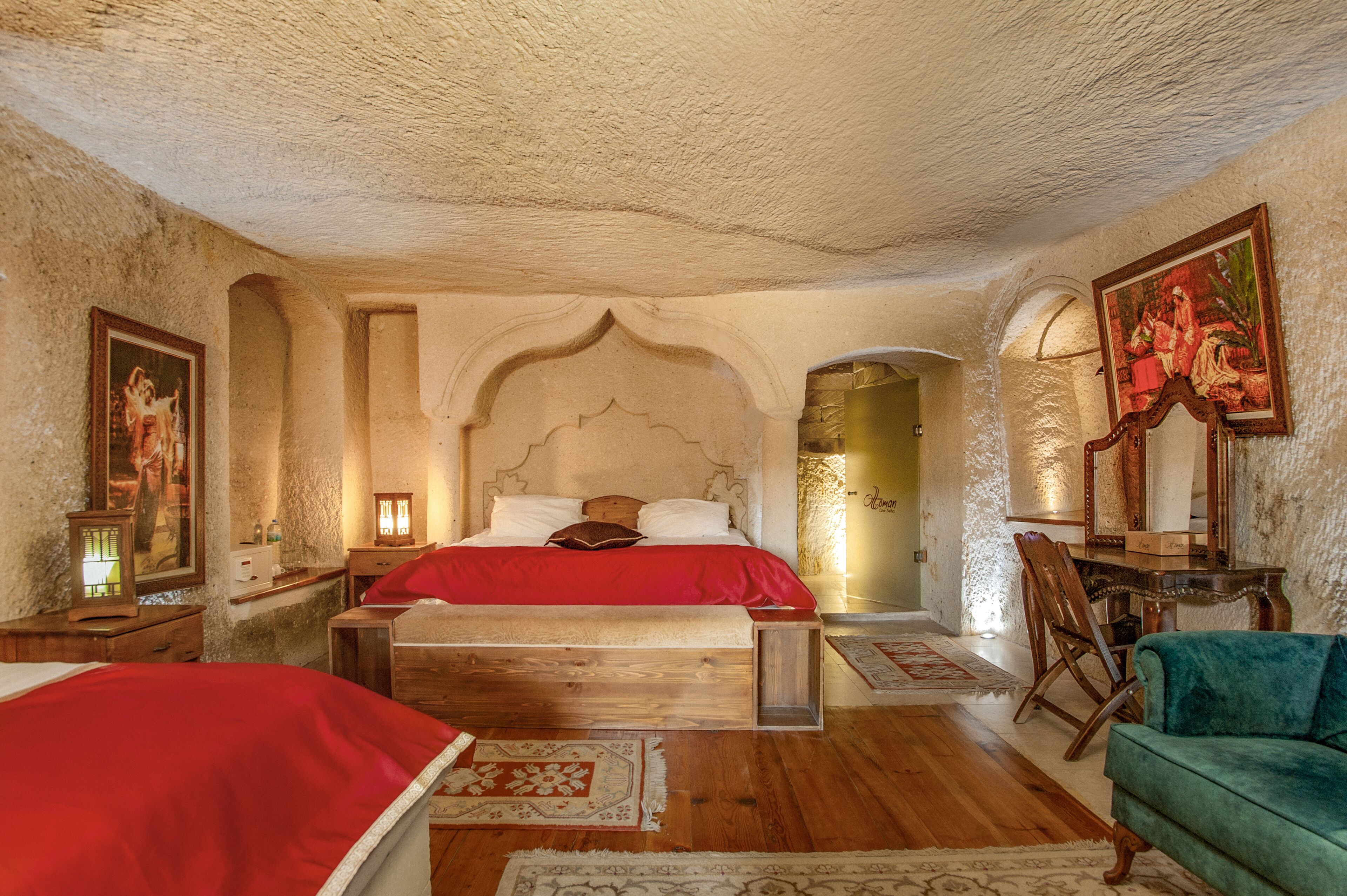 A bedroom with a large bed, wooden headboard, and a green armchair.