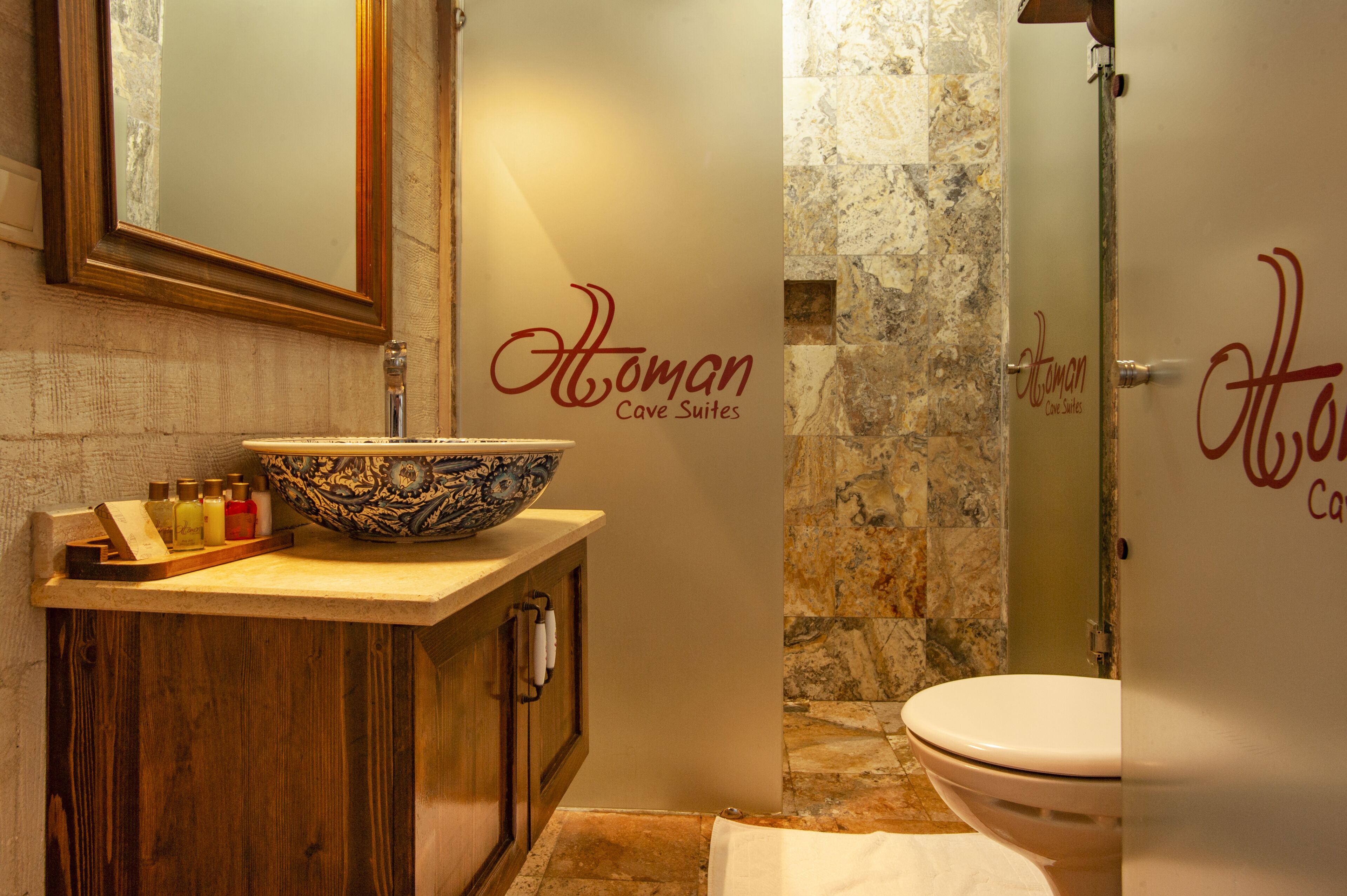 A bathroom with a wooden vanity, a large decorative bowl, and a shower area.