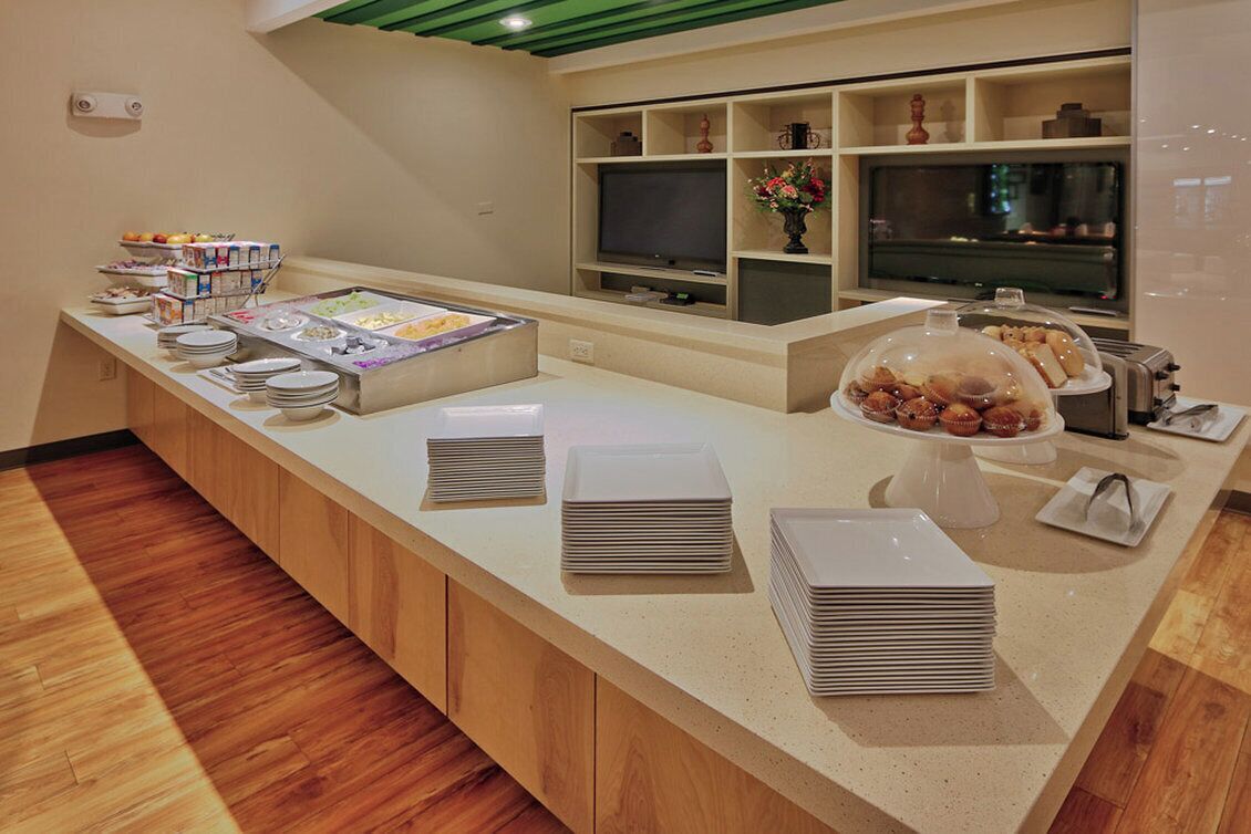 A buffet setup with a variety of food items, a television, and a decorative vase.