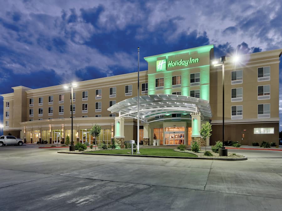 A Holiday Inn hotel with a large entrance, multiple floors, and a well-lit facade.