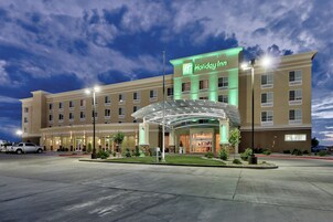 Un hotel Holiday Inn con una entrada amplia, varios pisos y una fachada bien iluminada.