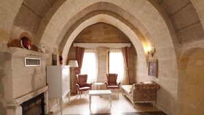 A room with a fireplace, two armchairs, a sofa, and a small table.