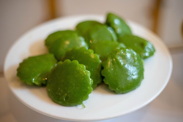 A white plate with several green, glossy objects. - Wangtai Hotel (Surat Thani)
