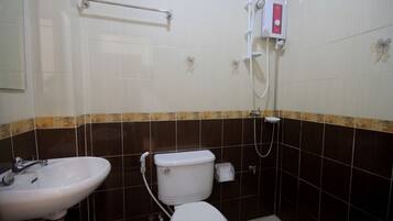 A bathroom with a white sink, toilet, and shower.