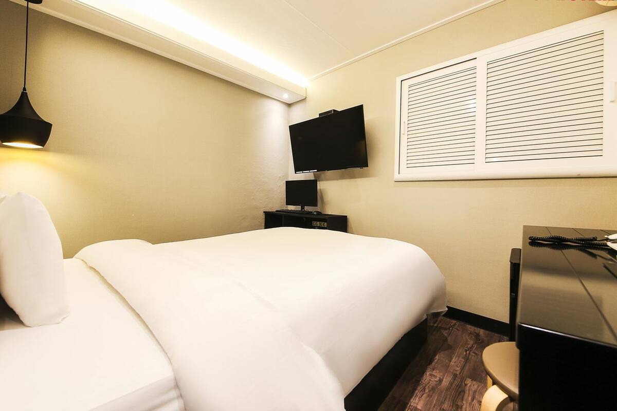 Luxe beddengoed, donsdekens, een bureau, verduisterende gordijnen