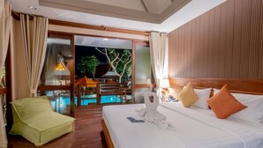 Habitación de hotel con cama, una silla verde, piso de madera y vistas a la zona de piscina exterior.