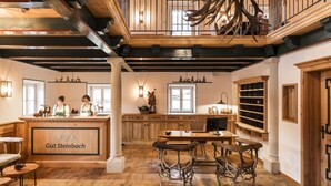 Ein rustikaler Innenraum mit Holzbalken, einer Bar und einem Essbereich mit besonderen Stühlen.