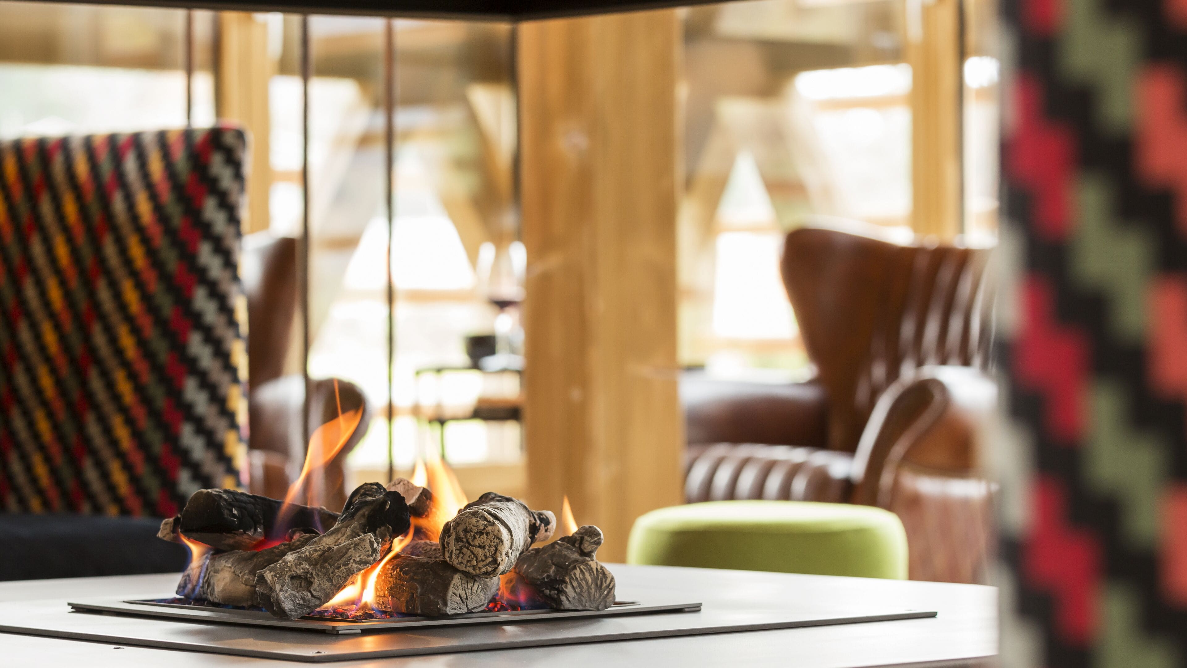Ein modernes Interieur mit Kamin, Holzmöbeln und einem gemusterten Teppich.