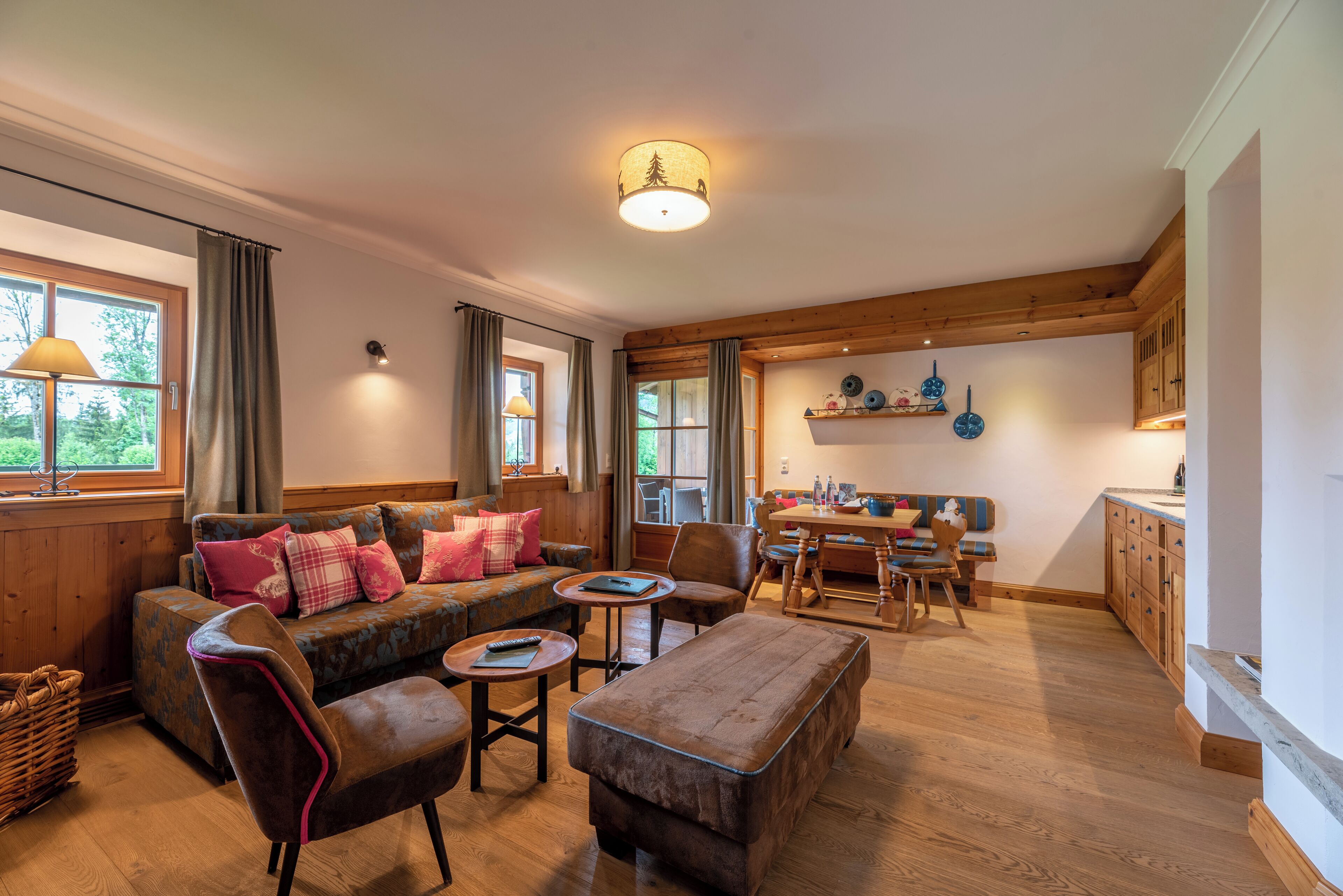 A cozy living room with a sofa, chairs, a coffee table, and a dining area with a table and chairs.