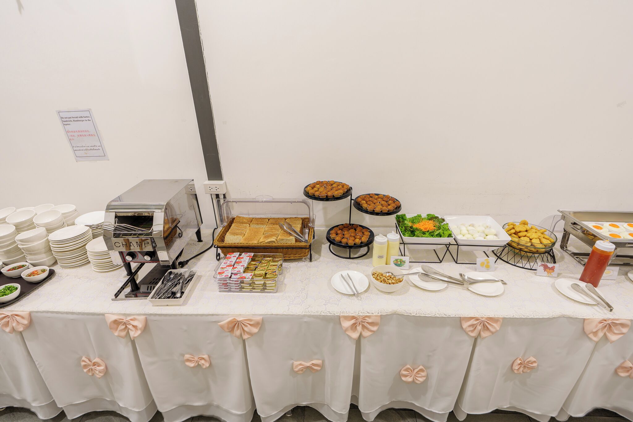 A buffet table with various food items, plates, and utensils.