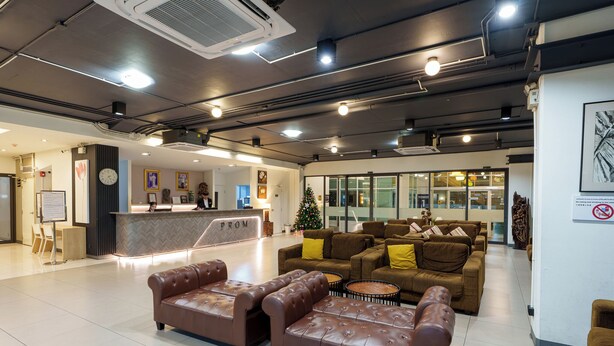 A modern lobby with leather sofas, a reception desk, and a Christmas tree.