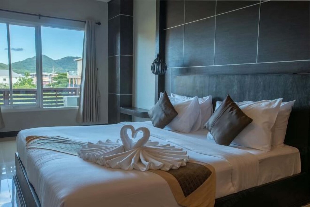 A hotel room with a large bed, a view of the mountains, and a modern design.