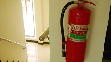 A red fire extinguisher mounted on a wall in a hallway.