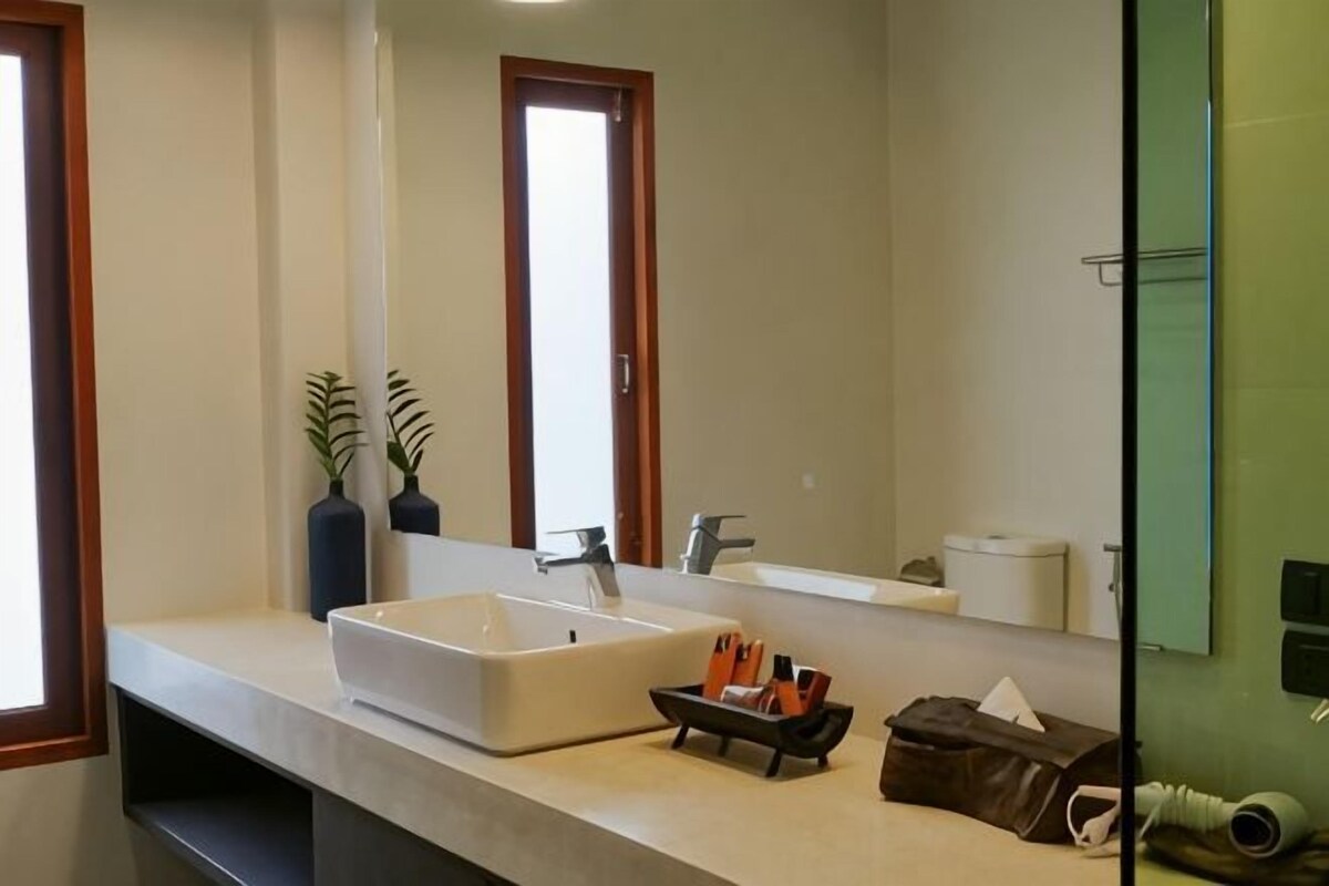 A bathroom with a large sink, mirror, and towel rack.