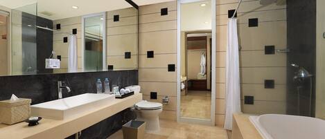 A modern bathroom with a large mirror, a white sink, a toilet, and a bathtub.